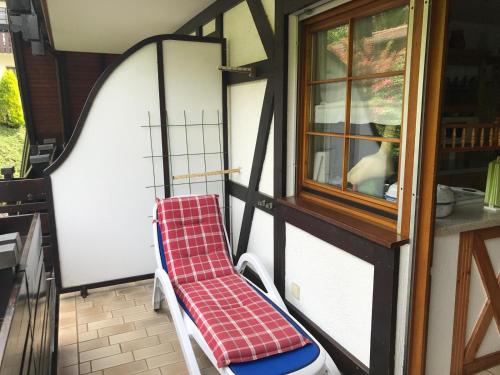 a red and white chair sitting on a porch at Haus Bachschwalbe in Sasbachwalden