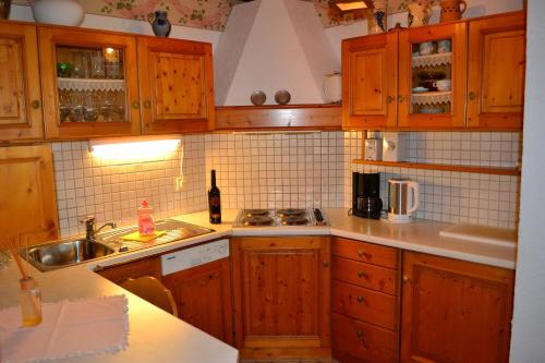 a kitchen with wooden cabinets and a sink at Haus Bachschwalbe in Sasbachwalden