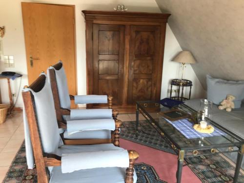 a living room with chairs and a glass table at Haus Bachschwalbe in Sasbachwalden
