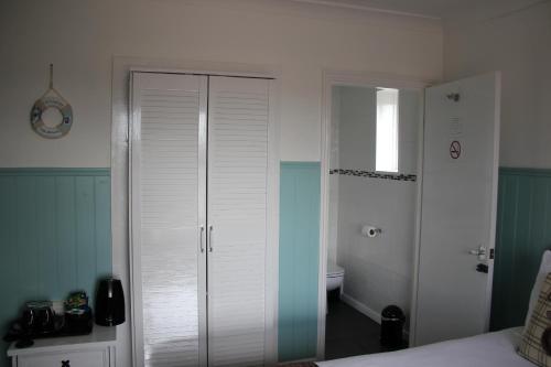um quarto com um armário branco e uma cama em The Elmfield em Great Yarmouth