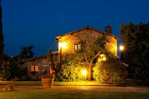 a large stone house at night with lights at SARNA Residence in San Quirico dʼOrcia