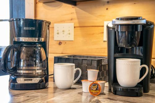 a coffee maker and coffee cups on a counter at Cabin In The Mountains By Avada Properties in Sevierville