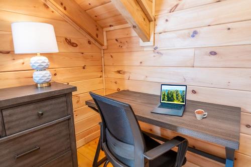 a laptop computer sitting on a wooden desk in a cabin at Cabin In The Mountains By Avada Properties in Sevierville