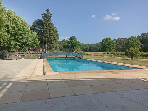 une piscine au milieu d'un parc dans l'établissement Le vallon des palombes, à Fox-Amphoux