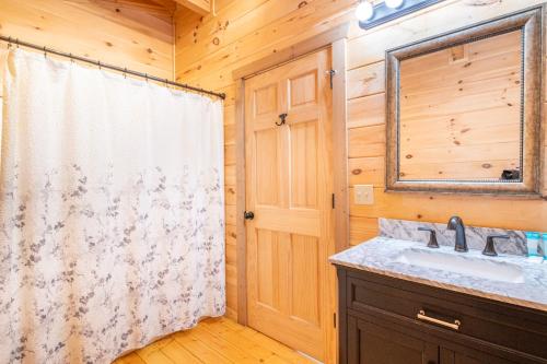 a bathroom with a sink and a mirror at Cabin In The Mountains By Avada Properties in Sevierville