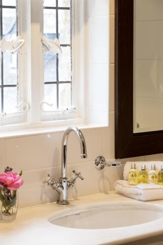a sink in a bathroom with a window above it at Old Swan & Minster Mill in Minster Lovell