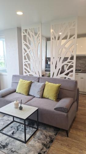 a living room with a couch and a table at Apartamentai su balkonu prie Akropolio Taikos pr 48 in Klaipėda