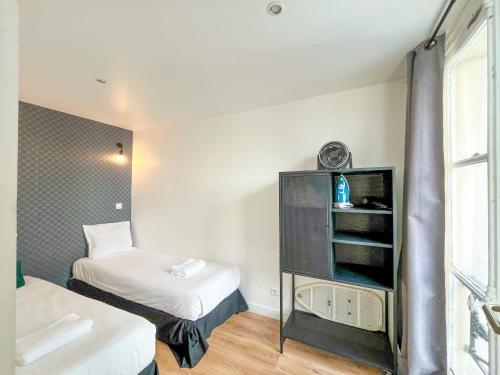 une petite chambre avec deux lits et une fenêtre dans l'établissement 148 - Urban Studio in Paris, à Paris