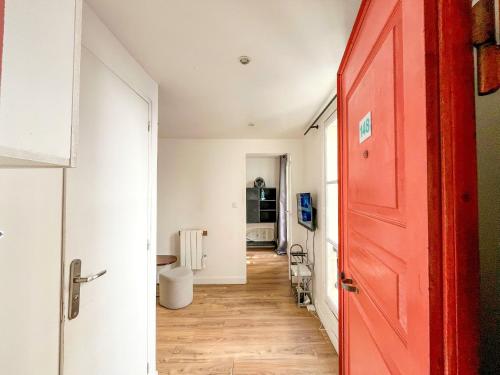 Cette chambre dispose d'une porte rouge et d'un couloir. dans l'établissement 148 - Urban Studio in Paris, à Paris