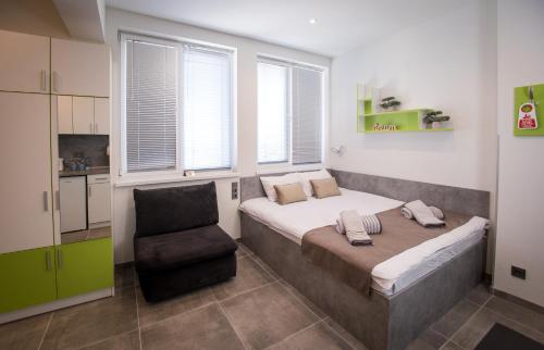 a bedroom with a bed and a chair in it at DORM BG pet-friendly Aparthotel in Stara Zagora