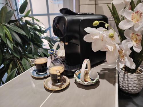 a coffee maker on a counter next to some flowers at Appartement a Millau in Millau