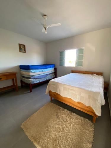a bedroom with a bed and a rug and a window at Denobes Ranch in Ribeirão Claro