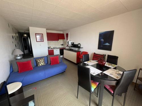 un salon avec un canapé bleu et une table dans l'établissement Appartement 4 Personnes avec Piscine et Parking au Cap d'Agde - FR-1-749-28, au Cap d'Agde