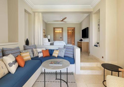 a living room with a blue couch and a bedroom at The Westin Resort, Costa Navarino in Romanós