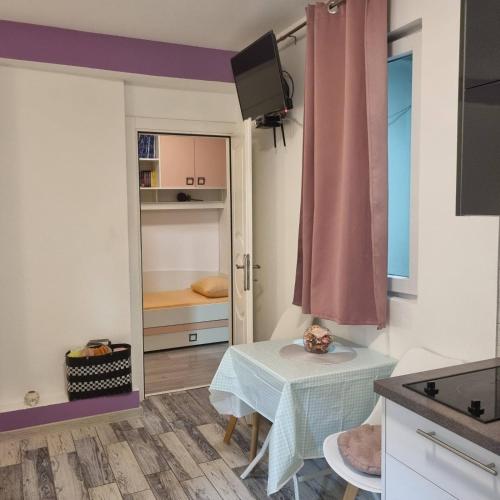 eine kleine Küche mit einem Tisch und einer Tür zu einem Schlafzimmer in der Unterkunft APARTMANI PAVLOVIC in Zelenika