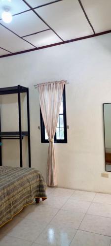 a bedroom with a bed and a window at Carcar Guesthouse in Barraca