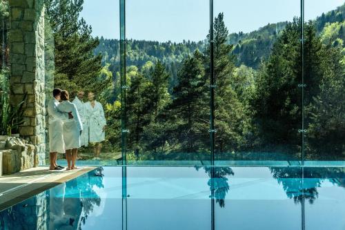 a bride and groom standing on the edge of a swimming pool at Hotel SPA Dr Irena Eris Krynica Zdrój in Krynica Zdrój