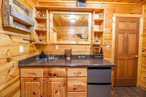 a kitchen with wooden cabinets and a sink in a cabin at Cozy Bear By Avada Properties in Gatlinburg