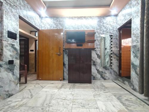 a lobby with a door and a television on a wall at PARADISE VILLA "Lord Krishna's Inn" in Vrindāvan