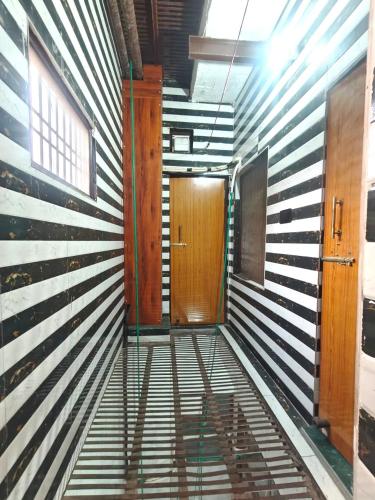a hallway with a wooden door in a room at PARADISE VILLA "Lord Krishna's Inn" in Vrindāvan