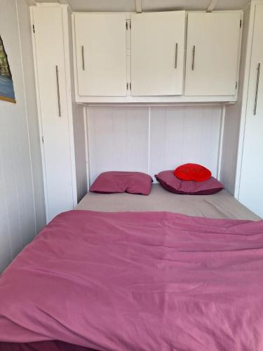 a bed with two pillows in a small room at Cosy 1 bedroom chalet near the woods in Anloo