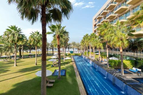 a view of the pool at the resort with palm trees at Rixos The Palm Hotel & Suites - Ultra All Inclusive in Dubai