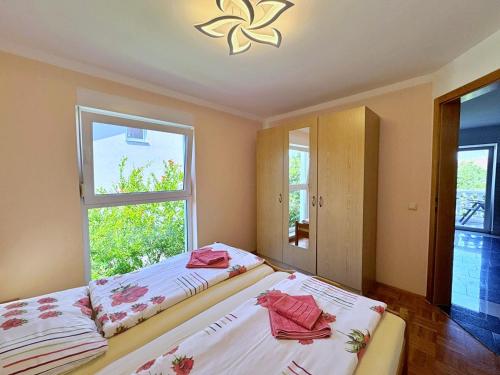 two beds in a room with two windows at Apartments Vodopija in Soline