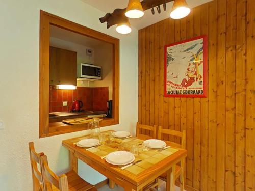 une salle à manger avec une table et des chaises en bois dans l'établissement Studio confortable - 4 pers, parking, animaux acceptés - FR-1-241-97, au Grand-Bornand