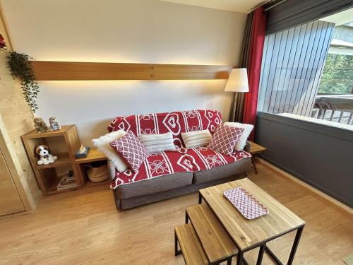 un salon avec un canapé rouge et une table dans l'établissement Studio à Megève avec parking souterrain et casier à skis - FR-1-597-189, à Megève