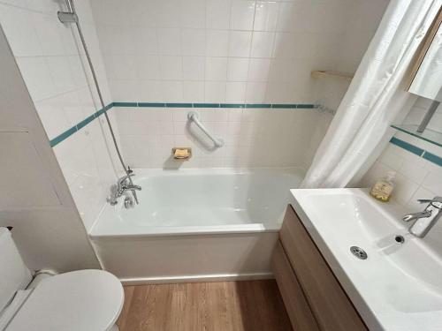 une salle de bain avec une baignoire blanche et des toilettes dans l'établissement Studio à Megève avec parking souterrain et casier à skis - FR-1-597-189, à Megève