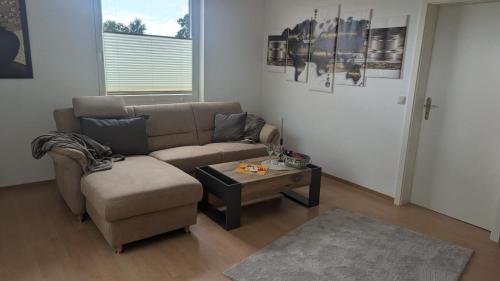 a living room with a couch and a coffee table at Ferienwohnung Am Deich, 86004 in Ostrhauderfehn