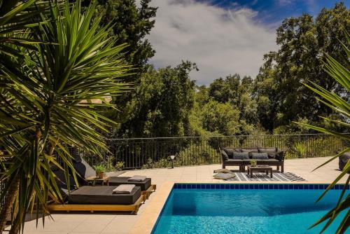 a swimming pool with two lounge chairs next to a swimming pool at Lourdas Hideaway in Kefallonia