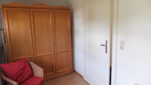 a room with a wooden cabinet and a red pillow at Ferienwohnungen Manz in Überlingen