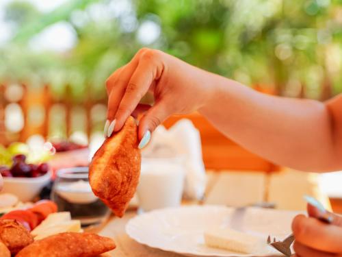 a person holding a piece of food on a table at Deve Mar Hotel in Borsh