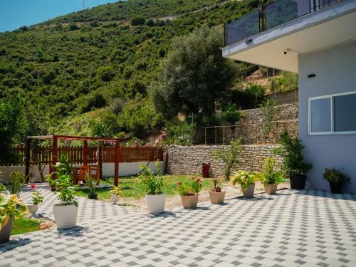 a patio with potted plants in front of a house at Deve Mar Hotel in Borsh