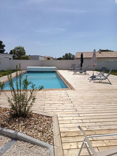 - une piscine avec des chaises et une personne debout à côté dans l'établissement Le Logis de Raphabel, à Saint-Palais-sur-Mer