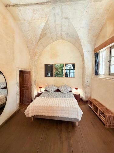 - une chambre avec un grand lit dans une pièce dotée d'un plafond dans l'établissement Les écuries de Lestang-Parade, à Arles
