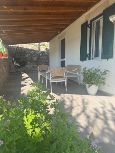 a patio with two chairs and a table on a house at Basil & Breeze in Lazaráta