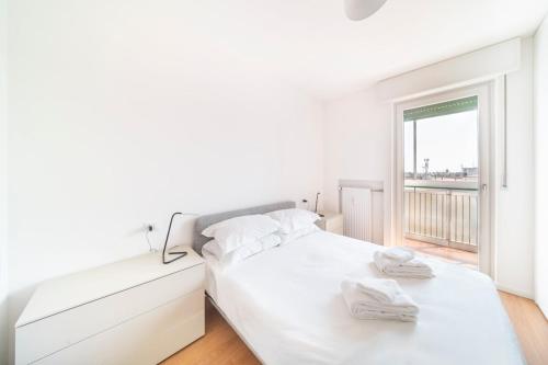 a bedroom with a white bed with towels on it at Luminosissimo Attico con Vista Panoramica su Udine in Udine