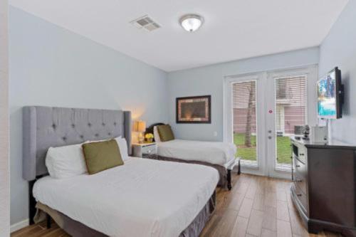 a bedroom with two beds and a flat screen tv at 3-Story sanctuary Condo in the heart of Orlando85 in Orlando