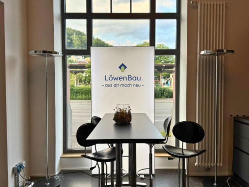 a table and chairs in a room with a window at Isaak Apartment Löwenbau E1-W06 in Waldshut-Tiengen