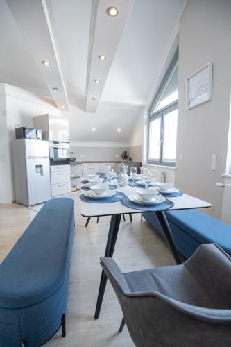a dining room with a table and blue chairs at CASA 8070 Exklusive Maisonette-Wohnung 91 qm für Familien, Gruppen, Geschäftsreisende, inklusive Parkplatz, WLAN, Kaffee und Tee, voll ausgestattet für 1 bis 9 Gäste, zentrumsnah, Autobahn A9 Ingolstadt-Süd, Donau, Auwaldsee und Gewerbegebiet in Ingolstadt