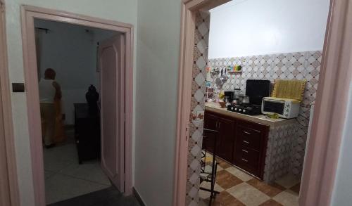 une personne debout dans une cuisine avec un four micro-ondes dans l'établissement Traditional Cosy Apartment Downtown Guéliz, à Marrakech