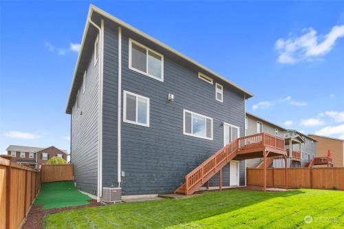 a gray house with a wooden fence at 19932 Stylish Spacious 5BR3BA Home in Spanaway in Spanaway