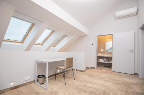 a white attic room with a desk and a chair at SPA Nida in Nida