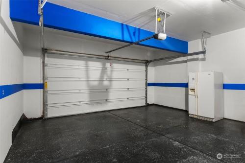 a garage with a white garage door and a blue wall at 19932 Stylish Spacious 5BR3BA Home in Spanaway in Spanaway