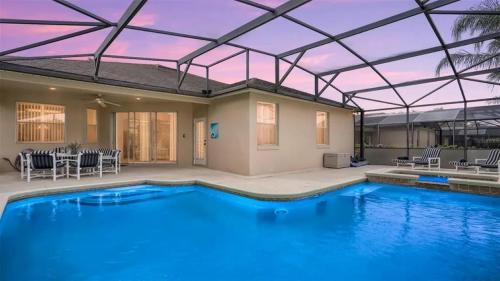 a large swimming pool with a roof over it at 509 Relax Play at This 6BR Pool Home in Haines City