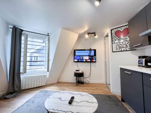 - un salon avec une grande fenêtre et une télévision dans l'établissement Urban Flat 150 - Pretty Flat in Center of Paris, à Paris