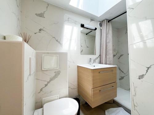une salle de bain blanche avec un lavabo et des toilettes dans l'établissement Urban Flat 150 - Pretty Flat in Center of Paris, à Paris