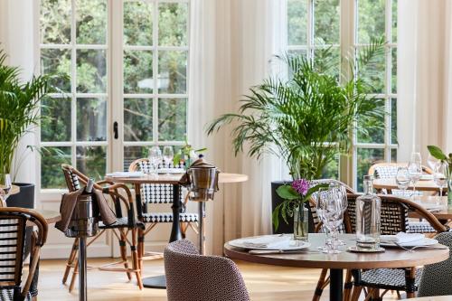 a restaurant with tables and chairs and windows at Villa Arthus-Bertrand in Noirmoutier-en-l'lle